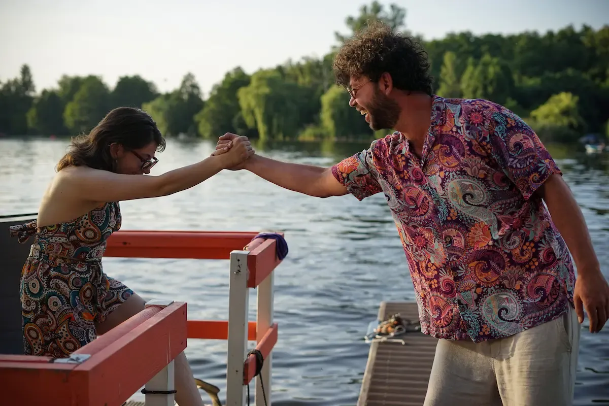 Two friends laughing in retro prints on a boat on the Spree